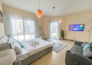 Un dormitorio con una cama, un sofá y un televisor. en Snug Studio With City Views, Perfect For Couples, en Dubái