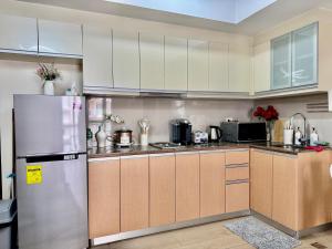 eine Küche mit Edelstahlkühlschrank und Schränken in der Unterkunft Cozy Home at Venice Luxury BGC in Manila