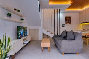 a living room with a couch and a dining room at Villa Moana - Nusa Dua in Nusa Dua