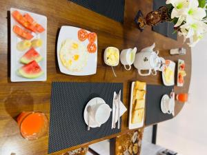 a table with plates of food and fruit on it at Kingz Kottage in Negombo