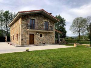 a small stone house with a dog sitting in front of it at El Molino de La Canal in Vega