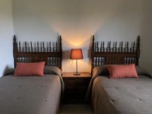 a bedroom with two beds and a lamp on a table at El Molino de La Canal in Vega