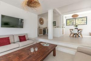 a living room with a couch and a table at Sunset villa with pool and seaview in Cala Tarida