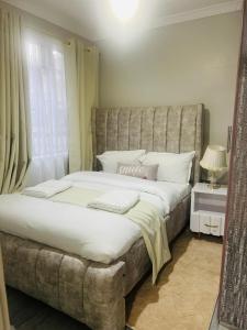 a bedroom with a large bed and a window at Jay Homes - Weber Generations Accommodations in Naivasha