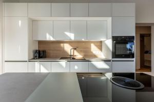 a white kitchen with a sink and a microwave at Alpine Suite Spot in Bad Mitterndorf