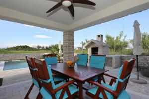 a wooden table and chairs on a patio with a fireplace at Villa Stella with heated swimming pool in Privlaka +44 photos