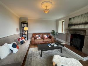 a living room with a couch and a fireplace at Idyllic Historical Country Retreat in Elkstone - Pass the Keys in Warslow