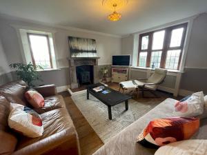a living room with two couches and a fireplace at Idyllic Historical Country Retreat in Elkstone - Pass the Keys in Warslow