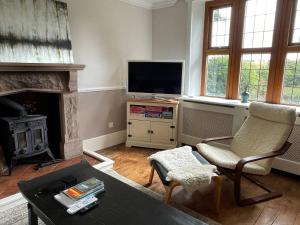 a living room with a fireplace and a tv at Idyllic Historical Country Retreat in Elkstone - Pass the Keys in Warslow +32 photos