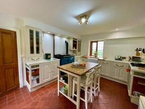 a kitchen with white cabinets and a wooden table at Idyllic Historical Country Retreat in Elkstone - Pass the Keys in Warslow