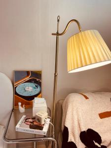 mesita de noche con lámpara y reloj despertador en Cozy guesthouse, 10 minutes from SNU Entrance Station, accommodation in Sharosu-gil, OTT, Nespresso machine, within 25 minutes by subway to Hongdae, Gangnam, Seongsu, Gwanaksan, up to 5 people, en Seúl