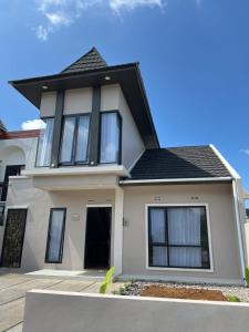 una casa blanca con techo negro en OSH! Omah Syariah Homestay, en Wonosobo 6 fotos más