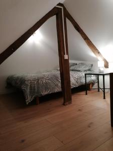 a bedroom with a bed and a table in a room at Bel appartement en plein centre in Lamballe