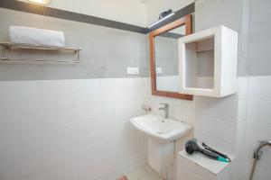 a white bathroom with a sink and a mirror at Lucky Seven Hikkaduwa in Hikkaduwa
