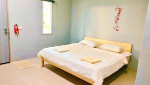 Postel nebo postele na pokoji v ubytování บ้านไม้หอมบูติค สวนผึ้ง