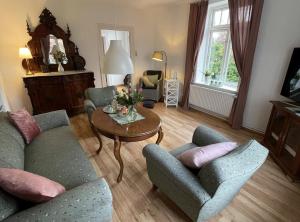a living room with two chairs and a table at Ferienhof Johannsen Ferienwohnung Gartenblick in Gelting