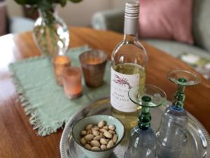 a table with a bottle of wine and a bowl of nuts at Ferienhof Johannsen Ferienwohnung Gartenblick in Gelting