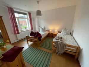 a bedroom with two beds and a window at Ferienhof Johannsen Ferienwohnung Gartenblick in Gelting +13 photos