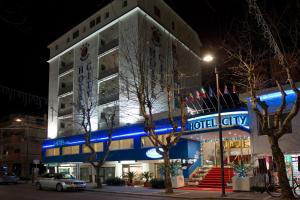 un bâtiment d'hôtel avec un panneau bleu de néon sur celui-ci dans l'établissement Hotel City, à Montesilvano