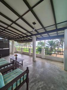 Habitación grande con 2 bancos y mesa. en Mermaids Inn, en Ratgama Hegoda
