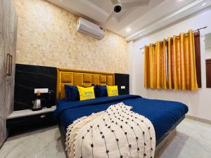 a bedroom with a blue bed with yellow pillows at Home Escape Cozy 1BHK Apartment Mahalaxmi Nagar in Indore
