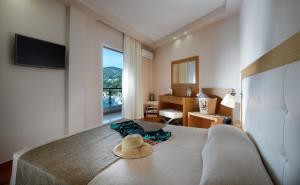 Panorama Botsaris Apartments في سيفوتا: غرفة نوم مع سرير مع قبعة عليه