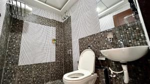 a bathroom with a toilet and a sink at Dojo Inn in Karmād