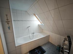 a bathroom with a bath tub with a window at NEU! Ferienwohnung Überblick in Ganzlin