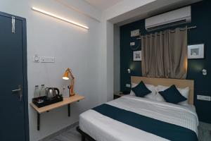 コルカタにあるHotel O Silver Key Deshapriya Park Near Kalighat Kali Templeの青い壁のベッドルーム1室