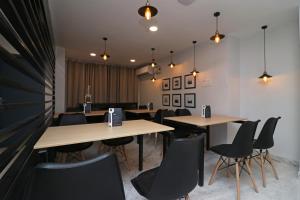 コルカタにあるHotel O Silver Key Deshapriya Park Near Kalighat Kali Templeのテーブルと椅子と照明のあるダイニングルーム