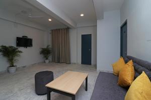 コルカタにあるHotel O Silver Key Deshapriya Park Near Kalighat Kali Templeのソファとテーブルのあるリビングルーム