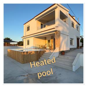 a house with a heated pool in front of it at Beach house La Marina in La Marina