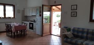 a kitchen and dining room with a table and a couch at Bio Agriturismo Le Giunchiglie in Alberese