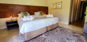 a bedroom with a large bed with white flowers on it at Mont Aux Sources Drakensberg Resort in Bonjaneni