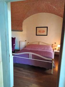 a bedroom with a bed with a purple comforter at villa il poggiale in Empoli