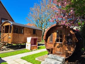 a wooden cabin with a door in a yard at Hotel Columbus und Glamping in Bremerhaven