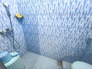 a bathroom with a shower with a toilet at Omah Kumendaman Homestay Jogja in Timuran +14 photos
