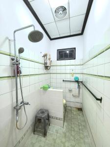 a bathroom with a shower and a toilet at Omah Kumendaman Homestay Jogja in Timuran