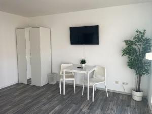 ein weißes Esszimmer mit einem weißen Tisch und Stühlen in der Unterkunft bookandstay24 Dietzenbach 2 Zimmerwohnung mit Balkon, Küche und Parkplatz-14 in Dietzenbach + 3 Fotos