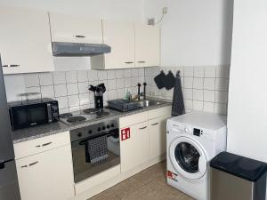 eine Küche mit Spüle und Waschmaschine in der Unterkunft bookandstay24 Dietzenbach 2 Zimmerwohnung mit Balkon, Küche und Parkplatz-14 in Dietzenbach
