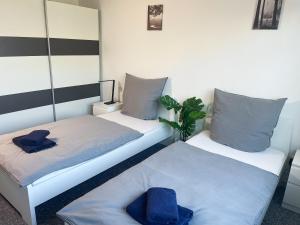 zwei Betten in einem Zimmer mit zwei Hüten darauf in der Unterkunft bookandstay24 Dietzenbach 2 Zimmerwohnung mit Balkon, Küche und Parkplatz-14 in Dietzenbach