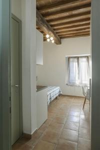 a kitchen with white walls and a wooden ceiling at The Optimist's House in Staggia