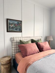 a bedroom with a bed with pink and green pillows at Luxury house, close to weddings! in Worragee