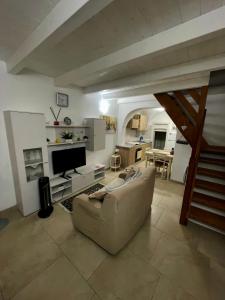 a living room with a couch and a television at La casa sotto il castello! in Carovigno