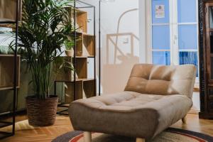 una sedia marrone in una stanza con una pianta di Ziegelloft Appartements - Altstadtnah und direkt an der Ilz a Passavia Altre 28 foto