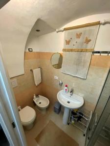 a small bathroom with a toilet and a sink at La casa sotto il castello! in Carovigno