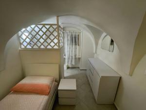 a small bedroom with two beds and a window at La casa sotto il castello! in Carovigno