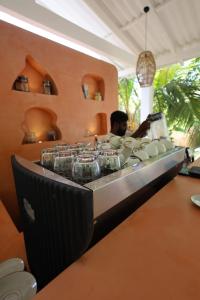 a bar with a row of cups on a counter at MAKAI Surf House in Ahangama