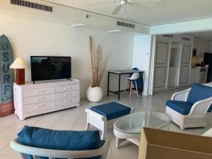 CupecoyOcean view gateway的客厅配有电视、椅子和桌子