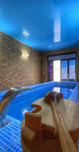 a swimming pool with a wooden table in the middle of it at Green villa panorama in Batumi